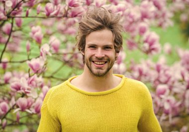 İlkbahar konsepti. Erkek çiçekli arka plan çözüldü. Bahar güzeli. Bahar sezonu. Botanik ve doğa. Mutlu bahar konsepti. Hippi çiçek aromasının tadını çıkarır. Tıraşsız adam manolya çiçeğini kokluyor.
