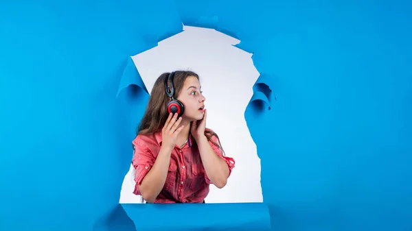 Menina adolescente ouvir música em fones de ouvido. infância feliz. bonito criança no estúdio fundo. — Fotografia de Stock
