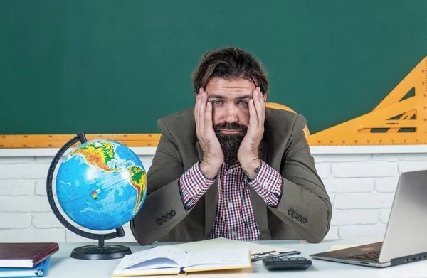 Profesor masculino con exceso de trabajo sintiéndose cansado sentado en el aula, relajarse —  Fotos de Stock