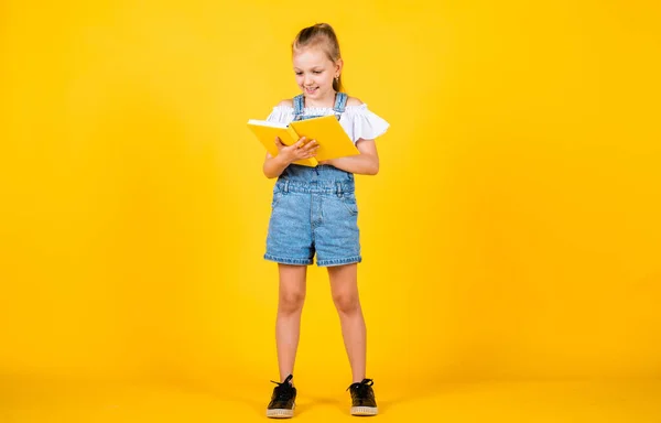 Χαριτωμένο παιδί πρόκειται να διαβάσει πληροφορίες από το βιβλίο, πίσω στο σχολείο — Φωτογραφία Αρχείου