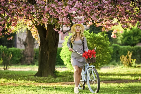 Transport ekologiczny. Wycieczka do ogrodu. Sportowa kobieta jeździ na rowerze retro. Podróż rowerem. Wiosenne wakacje. Jazda na rowerze. Dziewczyna i sakura kwitną. Wycieczki rowerowe. Zjednoczeni z naturą. Ekologiczny styl życia — Zdjęcie stockowe