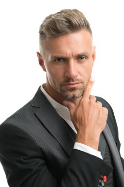 Sakallı olgun bir adam tıraşsız çene sakalına dokunur. Beyaz tenli, berber.