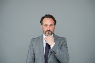 Sakallı ve bıyıklı olgun bir iş adamı şık bir takım elbise giyer, çevik işler yapar.