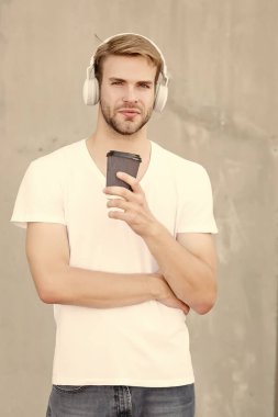 Paket içecek hareket halinde. Yakışıklı adam kahve içerken müzik dinliyor. Genç adam bardağı dışarıda tutuyor. Sağlıklı içki alışkanlığı. Sıcak çikolata ya da çay içmek. Müzik ve diyet. Modern hayat