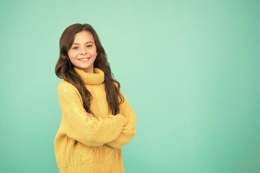 Duygusal bir bebek. Pozitif çocuk. Hayata olumlu yaklaşım. İlham. Pozitif ruh hali. Çocuk psikolojisi. Sevimli gülümseyen kız sarı süveter giyer turkuaz arka plan. Pozitif olma kavramı. İyi titreşimler.