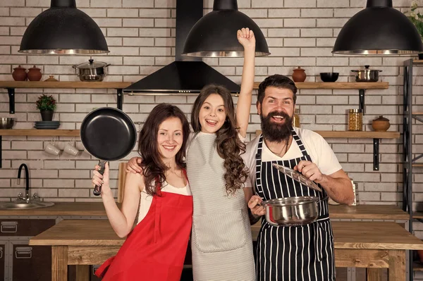 Birlikte daha lezzetli olur. Anne, baba ve kız önlükleri mutfakta. Yemek pişirme konsepti. Nefis bir kahvaltı hazırla. Öğle yemeği vakti. Aile birlikte yemek yaparken eğleniyor. Çocuklara yemek yapmayı öğret. Birlikte yemek pişirmek. — Stok fotoğraf