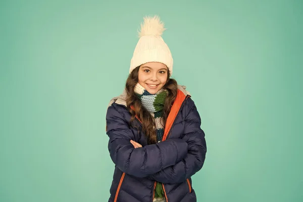 Mantenha seu bebê muito quente enquanto estiver ativo. Menina feliz com sorriso confiante. Bebé manter os braços cruzados fundo azul. Bebê pequeno desfrutar de estilo de inverno casual. Moda e estilo — Fotografia de Stock