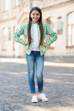 Sıradan bir bakış. Küçük çocuk ellerini açık havada tutuyor. Sıradan bir tarzı var. Modayı takip eden çocuklar giyer. Moda sokak kıyafetleri. Günlük giysiler. Konfordan ödün vermeden