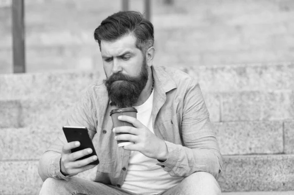 Descansa, bebe un poco de café. Hipster sostiene la taza para llevar y el teléfono inteligente. Descanso. Descanso. Descanso durante el día. Cada momento tiene su sabor — Foto de Stock