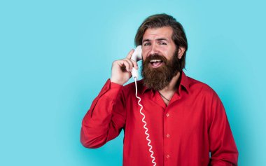 Tişörtlü, beyaz, vahşi hippi. Retro telefondan konuş, iletişim kur.