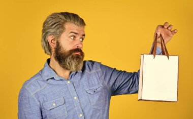 İyi alışverişler. Tatilleri kutlamaya hazır. Erkek moda satışı. Satın almada tasarruf. Adam online alışverişi seviyor. Alışverişten sonra üzgün hippi. Sakallı vahşi adam paketleri tutuyor.