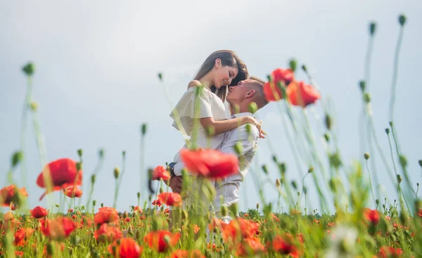 Expresando sentimientos. chica y chico en el campo. novios. pareja romántica con flores de amapola roja. vacaciones de verano familiares. feliz hombre y mujer enamorados disfrutar de clima primaveral. relaciones felices —  Fotos de Stock