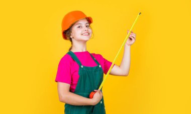 Korumalı miğferli genç kız müteahhit mezura, ölçü ve ölçü kullan