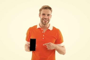 En son haberleri bul. Mutlu adam cep telefonunu işaret ediyor. Mobil cihaz. Modern hayat. Yeni teknoloji. Güzel alet. Taşınabilir yaşam tarzı. Yüksek teknoloji ürünleri