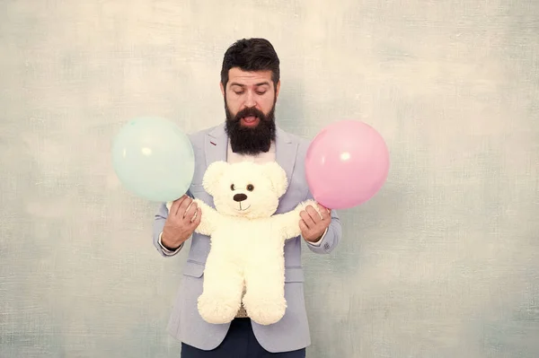 Sinto-me brincalhão. homem de negócios segurar urso brinquedo e balão. smoking homem pronto para encontro romântico. Presente do dia dos namorados. Feliz aniversário. ir para compras de presente. brutal barbudo hipster no formal desgaste — Fotografia de Stock