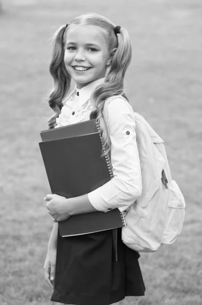 Rozwój wyobraźni. cute girl trzymać notatnik. szczęśliwa przedszkolanka z książką na szkolnym podwórku. Z powrotem do szkoły. Ciężko pracujące dziecko nosi plecak. koncepcja edukacji i czytania. Spodziewaj się sukcesu — Zdjęcie stockowe