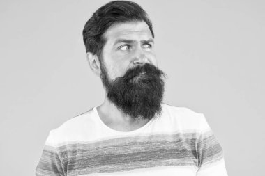 Erkek berber bakımı. Berber dükkanında stil kazan. Parlak bir hayat. Sarı arka planda vahşi sakallı adam. Erkek yaz modası. Olgun hipsterın bıyığı var. Hoşnutsuz görünen bir adam. Saçlarını güçlendir.