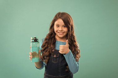 Sağlığın için en iyisi. Küçük kız şişeyi tutuyor. Detoks ve insanlar. Genç çocuk için sağlıklı bir içecek. Sağlık ve vücut dengesi için su iç. Susamış çocuk su içiyor. içme suyu susuzluğu önler.