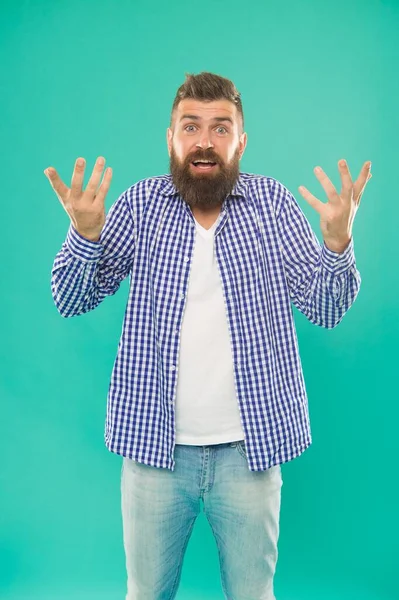 Homem barbudo confuso em camisa xadrez casual no fundo azul, embaraço — Fotografia de Stock