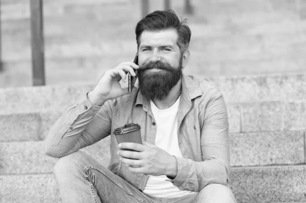 Een praatje met iemand. Gelukkige hipster drinken koffie praten over de telefoon buiten. Telefoontjes plegen. Mobiele telefoon verbinding. Nieuwe technologie. Het moderne leven. Mobiele telefoon maakt communicatie gemakkelijker — Stockfoto