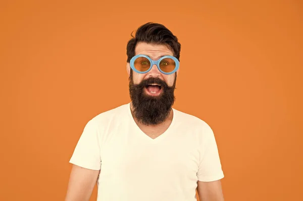 Perfekte Gläser für eine perfekte Party. Parteimann orangefarbenen Hintergrund. Bärtiger Mann trägt Party-Sonnenbrille. Fashion Party Accessoires. Spaß und Unterhaltung — Stockfoto