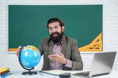 Yeryüzü ve dünya haritası ile sınıflarda coğrafya eğitimi alan öğretmen