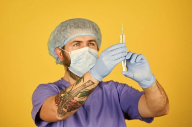 Aşı geliştirme. Şırıngada koronavirüs aşısı olan bir erkek hemşire. Tıbbi enjeksiyon. Sakallı doktor üniforma giyer şırınga aşısı kullanır. Grip aşısı. Yenilik. Panzehir. Dose enjeksiyon