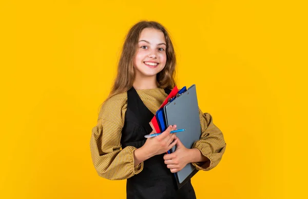 Snygg barnflicka som arbetar med pappersdokument i mapp, tillbaka till skolan — Stockfoto