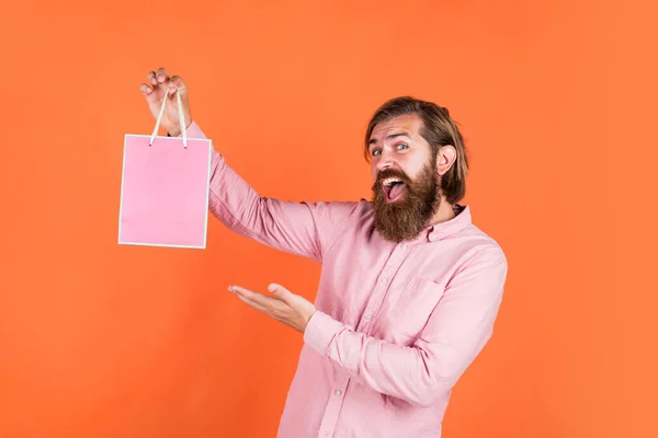 Para ti. hipster caucasiano brutal com presente. masculino ir às compras com a compra. Shopaholic bem sucedido. Homem barbudo pronto para as férias. venda e desconto. hipster maduro com barba segurar pacote presente — Fotografia de Stock