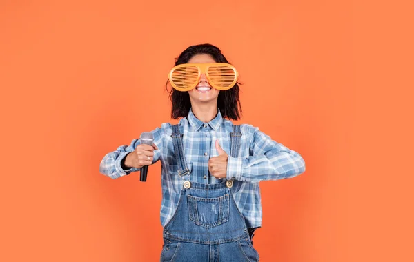 Bonito día. La cantante usa micrófono. alegre gestora de eventos mujer. chica cantando en karaoke. sentir felicidad y alegría. feliz hermosa dama en el estilo de mezclilla celebrar micrófono. música y vocal —  Fotos de Stock