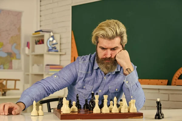 Thinking about next step. Chess is gymnasium of mind. Chess lesson. Strategy concept. School teacher. Board game. Figures on wooden chess board. Smart hipster man playing chess. Intellectual hobby
