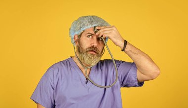 Steteskoplu cerrahi üniformalı bir adam. Sağlık sigortası. Ciddi doktor fonendoskop kullanır. Koronavirüs taşıyıcısı. Çin 'den gelen virüs enfeksiyonu. Test ve tedavi. sağlık ve sağlık kontrolü