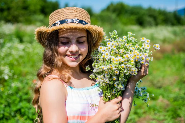 La belleza está tomando tiempo para dejarse mimar. Chica feliz sonrisa con montón de manzanilla. Belleza mirada de niño pequeño. Cuidado natural de la piel y del cabello. Peluquería. Spa y resort. Vacaciones de verano —  Fotos de Stock