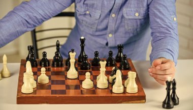 Entellektüel hobi. Tahta satranç tahtasındaki figürler. Bir sonraki adımı düşünüyorum. Strateji konsepti. Öğretmenim. Masa oyunu. Satranç oynuyorum. Geliştirme mantığı. Satranç minyatürdeki hayattır. Satranç dersi