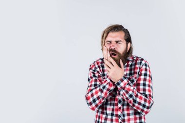 dişçi muayenesi. Sıradan kıyafetler içindeki yakışıklı sakallı adam. Acı çeken beyaz bir adam. Vahşi sakallı hippinin dişleri ağrıyor. Erkek dişlerinde ağrı hisseder. Sıradan bir erkeğin tıbbi bakıma ihtiyacı var.