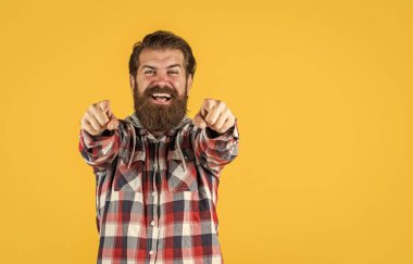 Genç ve vahşi. Kendine güvenen ve yakışıklı vahşi bir adam. kopyalama alanı. Ekose gömlekli yakışıklı sakallı adamın portresi. Sıradan kıyafetler giyen bir adam. vahşi, mutlu, sakallı adam içeride duruyor.