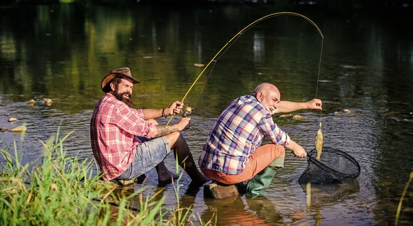 Felizes pescadores amizade. Dois amigos a pescar juntos. pesca grande jogo. relaxar na natureza. mosca peixe passatempo dos homens. pai aposentado e filho barbudo maduro. Aprendendo com o profissional — Fotografia de Stock