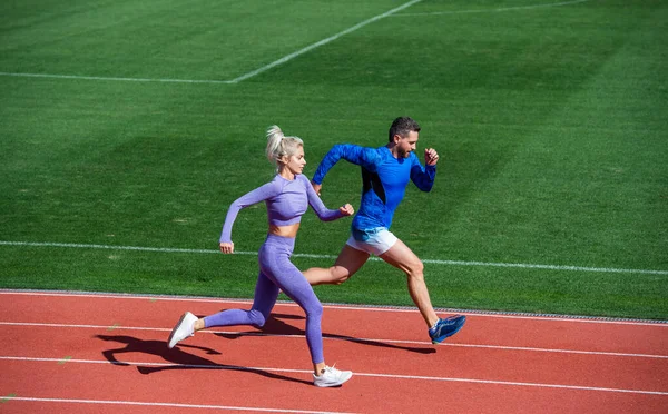 Mujer atlética y hombre de velocistas corren en pista de atletismo en el estadio, resistencia — Foto de Stock