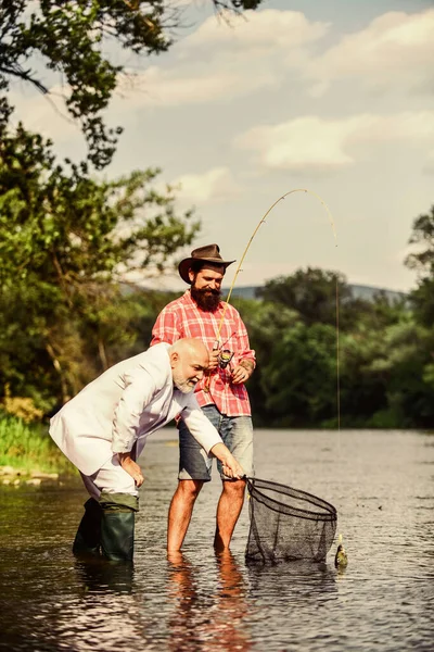 Des amis attrapant du poisson. Loisirs et loisirs. Attraper des poissons avec l'âme soeur. Homme barbu et pêche hipster brutale. Jour de famille. Équipe de pêche. Tranquillité et tranquillité. Des poissons d'eau douce. Journée active — Photo