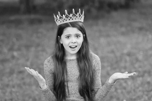 Cute girl golden crown outdoors green nature background, confusing expression concept — Stock Photo, Image