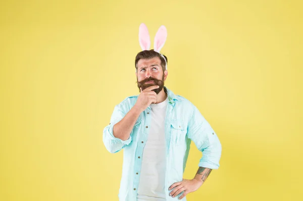Let me think. Man long rabbit ears. Bearded man Easter rabbit costume. Easter bunny or hare. Hipster dressed for Easter party. Easter bunny symbol of fertility and spring. Thoughtful guy. Remember