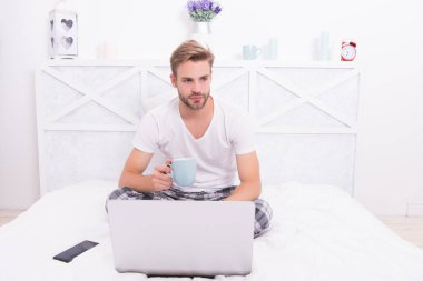 Hastalandığında. Adam yatakta çay içiyor. COVID-19 'a karşı bitkisel ilaç. Çayın antiviral aktivitesi