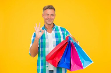 Neşeli alışveriş meraklısı adam alışveriş merkezinden bir sürü hediye paketi al ve iyi niyet göster, mükemmellik