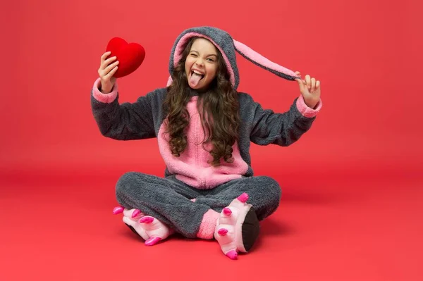 Reconoce tu verdadera alegría. Chico gracioso sostiene el corazón en mono de conejo. Fiesta de San Valentín. Fiesta de pijama — Foto de Stock