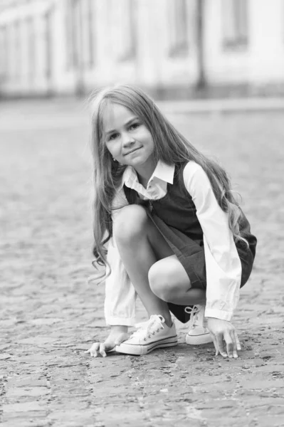 Μικρό παιδί με μακριά μαλλιά στο σχολείο παιχνίδι στολή σε εξωτερικούς χώρους του σχολείου, παιδική ηλικία — Φωτογραφία Αρχείου
