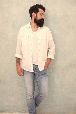 Erkekler için stil ipuçları. Yakışıklı, çekici bir hippi. Moda erkek modeli. Sakallı, olgun bir hippi. Vahşi adamın kumral saçları var. Seksi bir adamın portresi. Kot tarzı. Kentsel bağlamda genç sakallı model