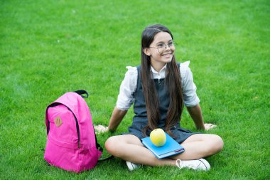 Beyninin sağlığını koruyorum. Mutlu çocuk yeşil çimlerde rahatla. Okul tatili. Beslenme eğitimi. Okul yemeği. Sağlıklı beslenme alışkanlıkları. Öğrenmek için yemek