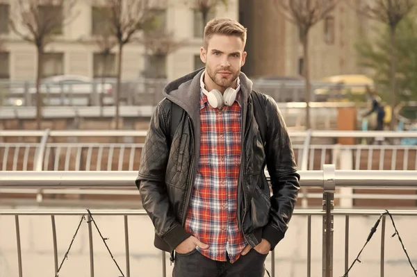 In contemporary style. Handsome guy on modern urban environment. Modern man wear headphones outdoor. Modern music technology. New technology. Modern life. Casual fashion trends
