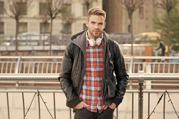 En estilo contemporáneo. Un tipo guapo en un entorno urbano moderno. Hombre moderno usar auriculares al aire libre. Tecnología de música moderna. Nueva tecnología. La vida moderna. Tendencias de moda casual — Foto de Stock