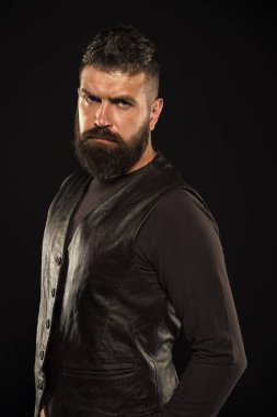 Kendine güvenen ve vahşi stil siyah arka plan. Berber dükkanı konsepti. Bıyık bırak. Moda modeli. Katı, olgun bir yüz. Yüz kılları. Erkek yüzü. Yakışıklı bir yüz. Siyah deri elbiseli sakallı adam.